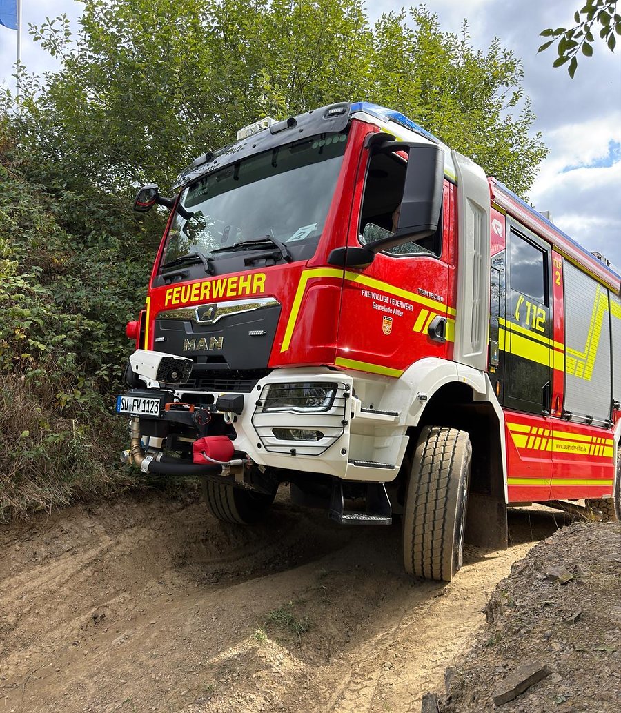 Feuerwehr-LKW in Schräglage auf einer ausgefahrenen Steigung